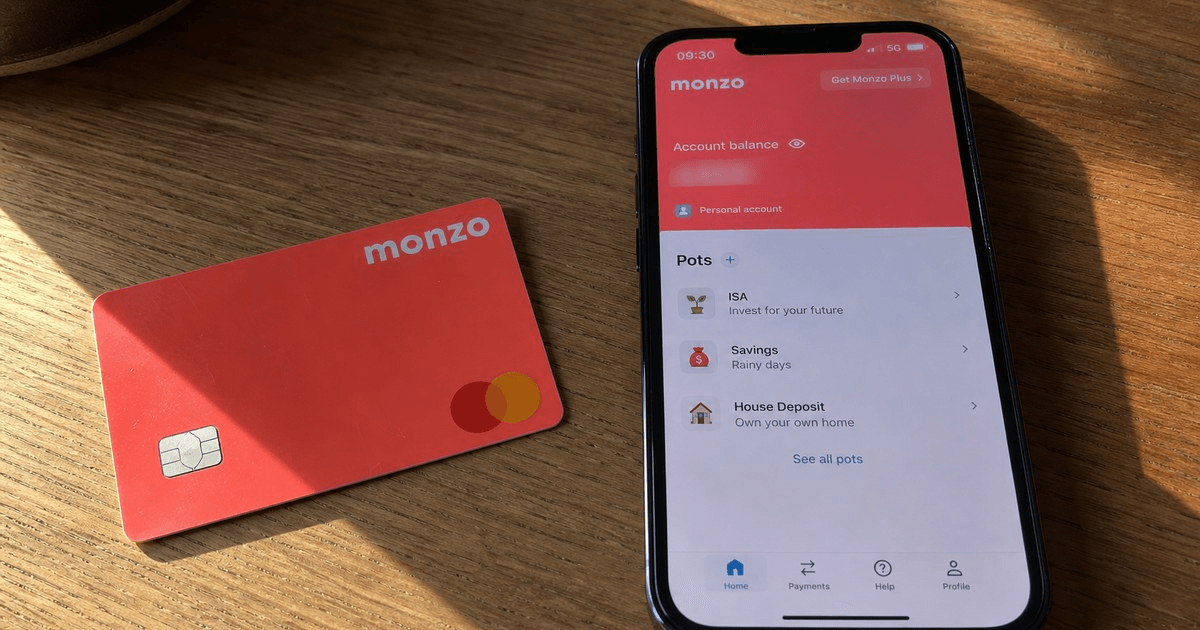 Monzo coral debit card and app on a desk, Monzo Business referral code £50 each side