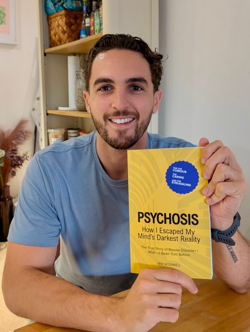 Mike McDonnell holding his book Psychosis: How I Escaped My Mind's Darkest Reality